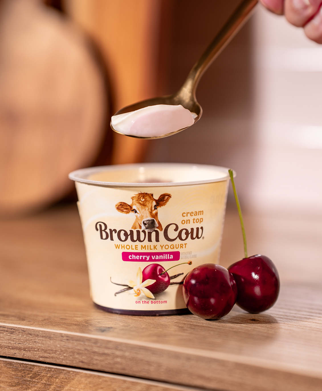 Spoon scooping Brown Cow cherry vanilla yogurt.